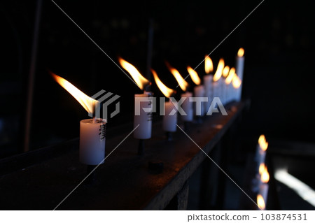 Dozens of candles lined up 103874531