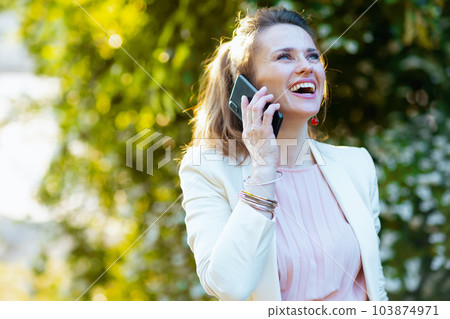 happy stylish woman in city talking on smartphone happy stylish woman in city talking on smartphone 103874971