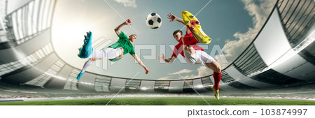 Bottom view of two football players in motions during game at 3D open playground, arena, kicking ball in jump 103874997