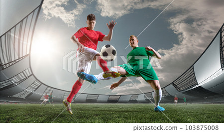 Dynamic image of two competitive men, football players in motions, playing on 3D arena outdoors. Match 103875008