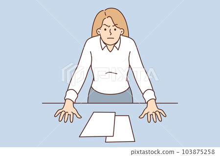 Bossy business woman with displeased look stands near office desk, wanting to chastise employees 103875258
