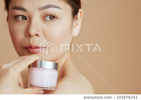 young asian female with facial cream jar young asian female with facial cream jar 103876241
