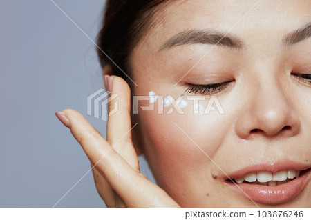 Closeup on modern asian female with facial cream on face 103876246