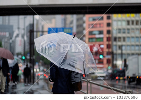 一個女人撐著雨傘走在雨街上的背影 一個女人撐著雨傘走在雨街上的背影 103876696