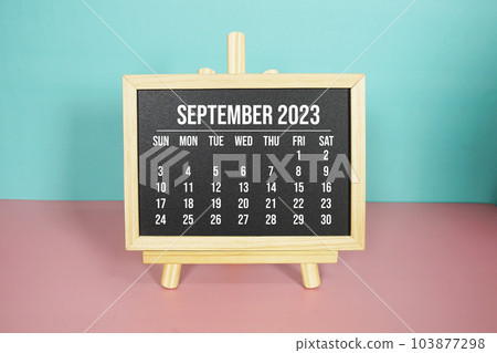 September 2023 monthly calendar on easel stand on pink and blue background 103877298