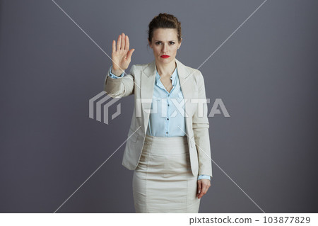 woman worker in light business suit showing stop gesture 103877829