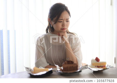 一個女人想知道吃哪個蛋糕 一個女人想知道吃哪個蛋糕 103877928