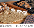 Food background with homemade cookies. The process of making cookies in the kitchen with dough and molds. 103878426