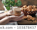 Food background.Healthy homemade food.Elderly woman's hands serve a cup of tea with milk. 103878437