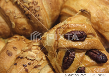 French puff pastry and croissant with toppings. Freshly baked sweet buns couple flaky pastry with almond nuts in a white plate for dessert. Delicious Breakfast or brunch concept. Burekas, turnovers. 103878485