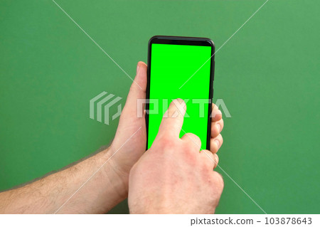 Young man hand use smartphone with green screen on green background. Gestures pack. Male hand touching, clicking, tapping swiping on black phone chroma key display. Close up Device. Modern Technology Young man hand use smartphone with green screen on green background. Gestures pack. Male hand touching, clicking, tapping swiping on black phone chroma key display. Close up Device. Modern Technology 103878643