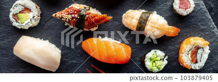 Sushi overhead flat lay panorama. Rolls, maki, nigiri on a black background Sushi overhead flat lay panorama. Rolls, maki, nigiri on a black background 103879405