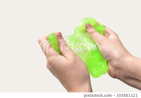 Hand Playing with textured slime on white background. Teen hand holding green shining slime with bubbles, stretching gooey substance. Teenage Girl squeezing slime toy to the sides. Liquid toy. Handgum 103881121