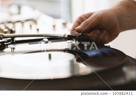DJ hand adjusting a needle on a vinyl record 103882411