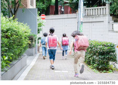 Elementary school students running on the sidewalk 103884730
