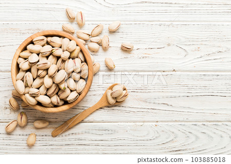 Fresh healthy Pistachios in bowl on colored table background. Top view Healthy eating concept. Super foods 103885018