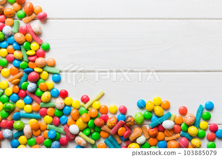 Mixed collection of colorful candy, on colored background. Flat lay, top view. frame of colorful chocolate coated candy 103885079