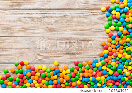 Mixed collection of colorful candy, on colored background. Flat lay, top view. frame of colorful chocolate coated candy 103885081