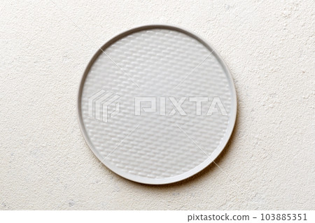 Top view of empty light plate on cement background. Empty space for your design Top view of empty light plate on cement background. Empty space for your design 103885351