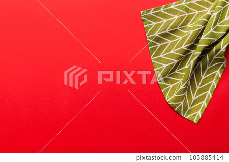 top view with green kitchen napkin isolated on table background. Folded cloth for mockup with copy space, Flat lay. Minimal style 103885414