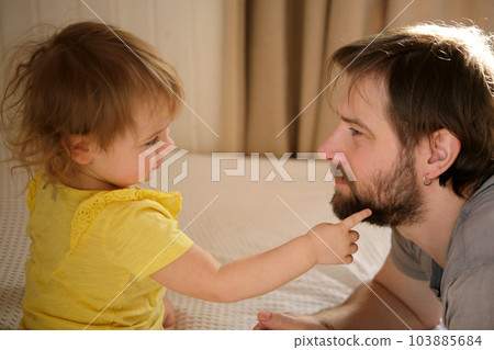 Happy Father with Daughter, Tiny Girl. One Year Baby Smiling, Laughing, Looking up at Daddy. Man Showing Affection to Child. Candid Real Emotion. Beard Dad and Little Kid. Authentic Family Lifestyle. Happy Father with Daughter, Tiny Girl. One Year Baby Smiling, Laughing, Looking up at Daddy. Man Showing Affection to Child. Candid Real Emotion. Beard Dad and Little Kid. Authentic Family Lifestyle. 103885684