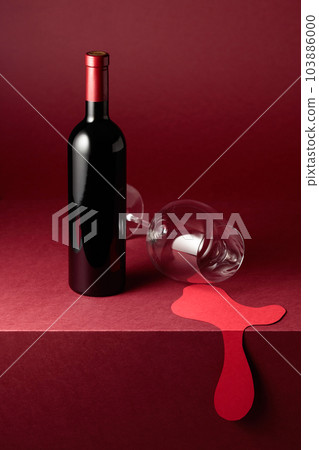 Bottle and glass of red wine on a red background. Bottle and glass of red wine on a red background. 103886000
