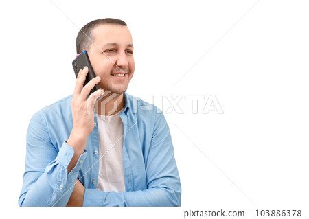 Young man in a denim shirt talking on a mobile phone on a white background. Young man in a denim shirt talking on a mobile phone on a white background. 103886378