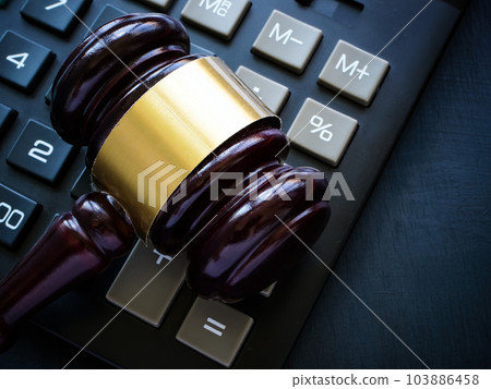 The gavel lies on the calculator as a concept of economic crimes and tax evasion. 103886458