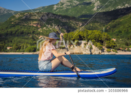 Young women Having Fun Stand Up Paddling in blue water sea near st stefan island in Montenegro. SUP 103886966