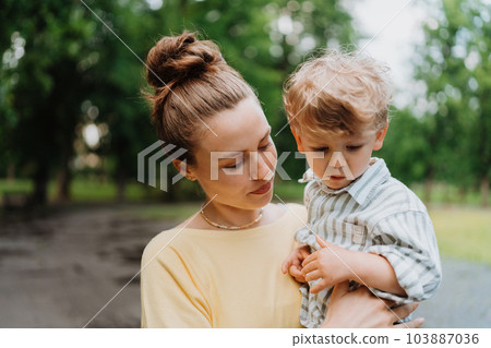 Young mother with little son on together walk after work day. 103887036