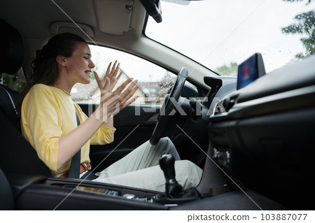 Angry woman sitting in electric car with drained battery. Angry woman sitting in electric car with drained battery. 103887077