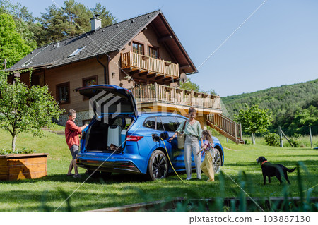 Happy family preparing for holiday, charging their electric car. 103887130