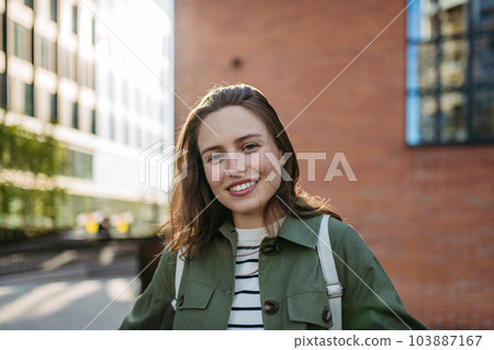 Portrait of young woman in a city. 103887167