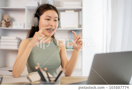 Asian student chatting or exchanging knowledge through laptop video call, Education through wireless education system, Conversations with teachers and classmates, Online learning, Study at home. Asian student chatting or exchanging knowledge through laptop video call, Education through wireless education system, Conversations with teachers and classmates, Online learning, Study at home. 103887774