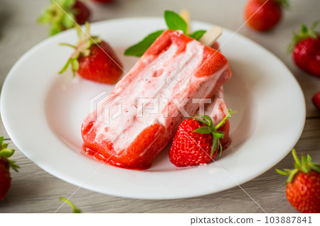 homemade strawberry ice cream on a stick in a plate with strawberries homemade strawberry ice cream on a stick in a plate with strawberries 103887841