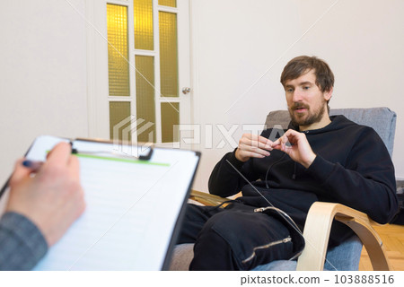 A man for a consultation in the office of a psychologist. Emotional health problems. 103888516