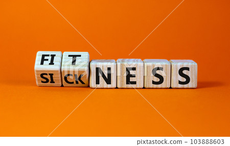 Fliped a wooden cube and changed the inscription 'sickness' to 'fitness' or vice versa. Beautiful orange background, copy space. Business concept. Fliped a wooden cube and changed the inscription 'sickness' to 'fitness' or vice versa. Beautiful orange background, copy space. Business concept. 103888603
