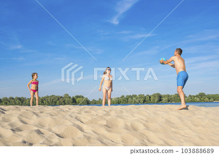 Family on the river bank playing beach volleyball on a sunny, summer day Family on the river bank playing beach volleyball on a sunny, summer day 103888689