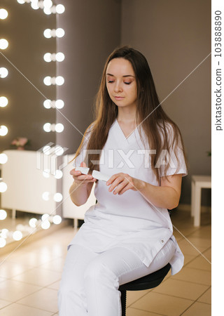 Young positive cosmetologist woman holds a device for ultrasonic facial cleansing in her hands Young positive cosmetologist woman holds a device for ultrasonic facial cleansing in her hands 103888890