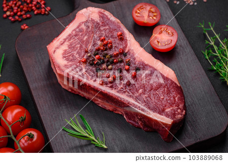 Fresh juicy raw new york beef steak with salt, spices and herbs 103889068