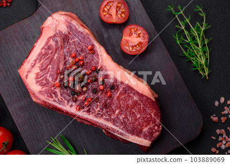 Fresh juicy raw new york beef steak with salt, spices and herbs 103889069