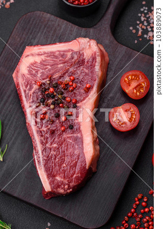Fresh juicy raw new york beef steak with salt, spices and herbs 103889073