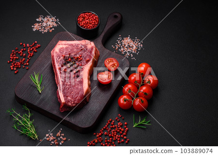 Fresh juicy raw new york beef steak with salt, spices and herbs 103889074