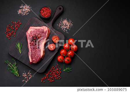 Fresh juicy raw new york beef steak with salt, spices and herbs 103889075