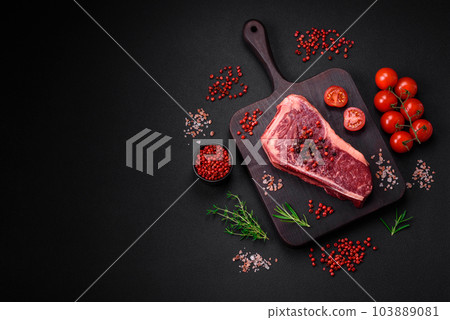 Fresh juicy raw new york beef steak with salt, spices and herbs Fresh juicy raw new york beef steak with salt, spices and herbs 103889081