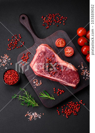 Fresh juicy raw new york beef steak with salt, spices and herbs Fresh juicy raw new york beef steak with salt, spices and herbs 103889082