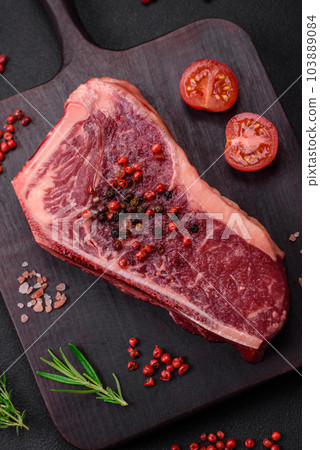 Fresh juicy raw new york beef steak with salt, spices and herbs 103889084