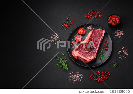 Fresh juicy raw new york beef steak with salt, spices and herbs 103889090