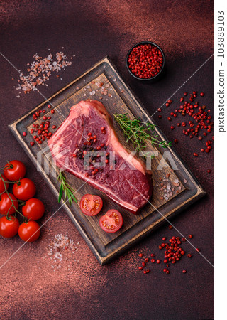 Fresh juicy raw new york beef steak with salt, spices and herbs 103889103