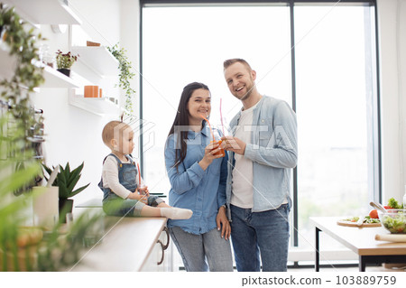 Parents and child spending time together in kitchen Parents and child spending time together in kitchen 103889759